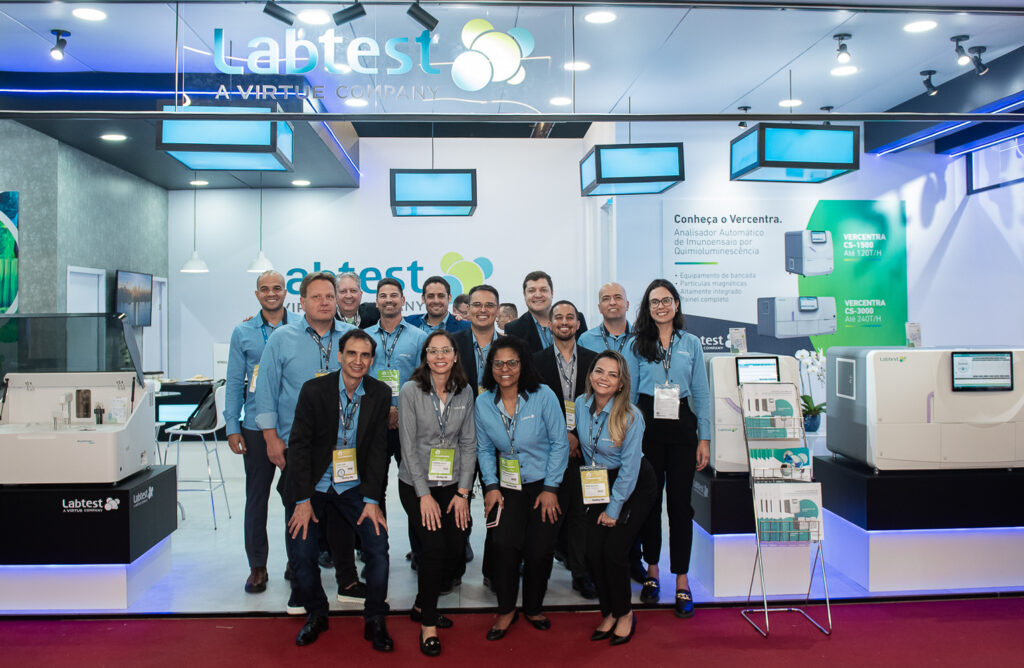 Photo of labetest employees in front of exhibition both with virtuedx products